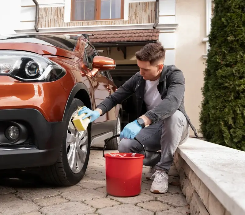 Lavage auto à domicile Muneville-le-Bingard : professionnel intervenant sur un véhicule